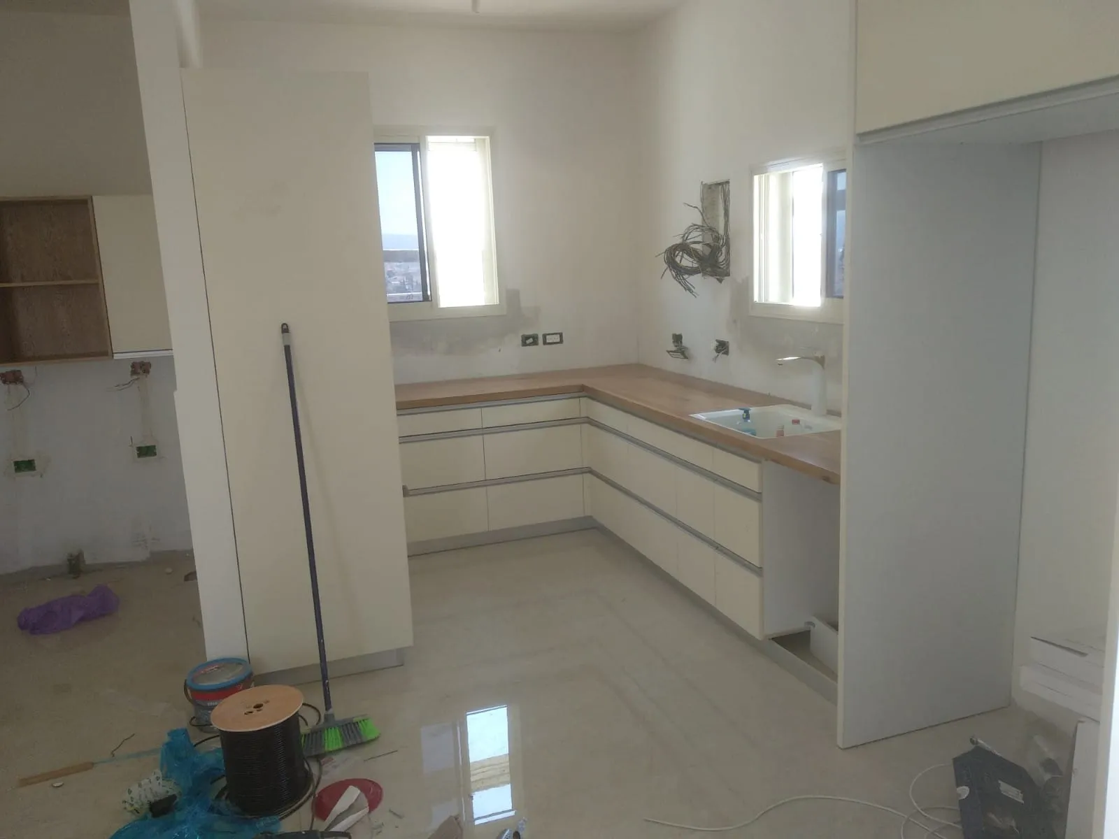 מטבח לבן עם משטח עבודה בגוון עץ — מטבחים
